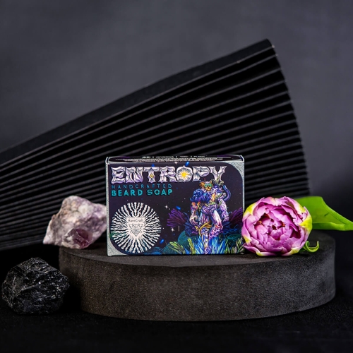 Mydlo-do-brody-w-kolorowym-opakowaniu-z-napisem-ENTROPY-HANDCRAFTED-BEARD-SOAP-na-okraglej,-ciemnej-podstawie,-obok-kamieni-szlachetnych-i-rozowej-peonii-na-zielonym-lisciu,-na-ciemnym-tle-z-nowoczesnym-wzorem..jpg
